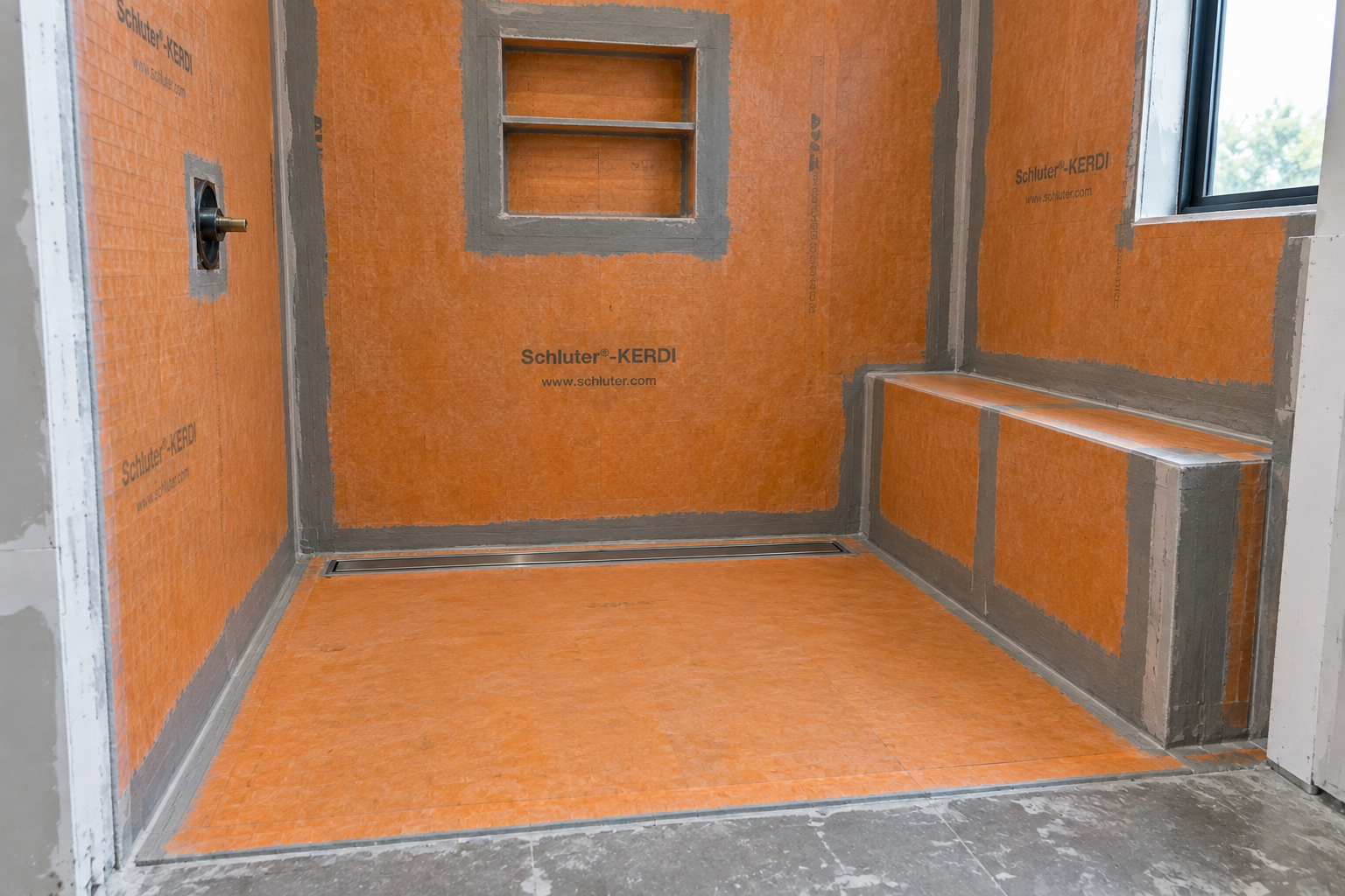 Curbless shower waterproofing with recessed niche and built-in bench in Irvine